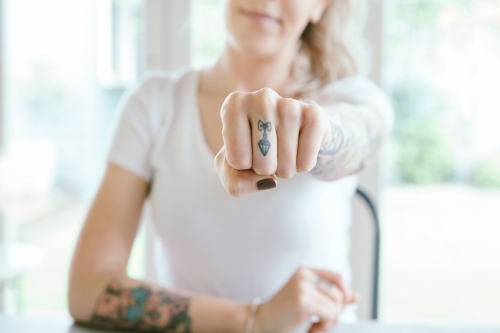 Pretty young girl punching fist sending a message of power - Australian Stock Image