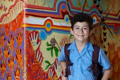 Primary school student at school, with wall mural behind - Australian Stock Image
