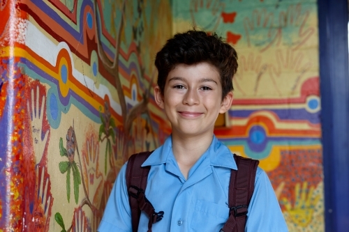 Primary school student at school, with wall mural behind - Australian Stock Image