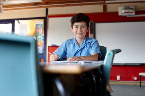 Primary school student in classroom working on homework - Australian Stock Image
