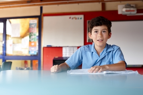 Primary school student in classroom working on homework - Australian Stock Image