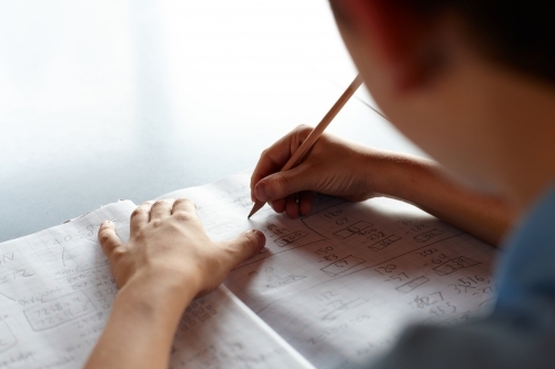 Primary school student in classroom working on homework - Australian Stock Image