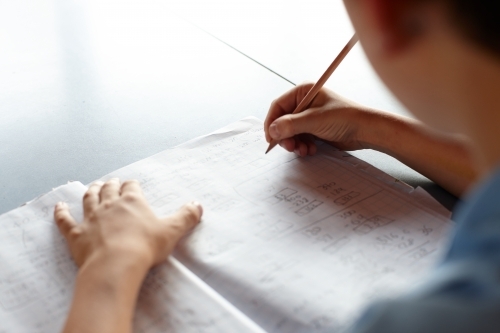 Primary school student in classroom working on homework - Australian Stock Image