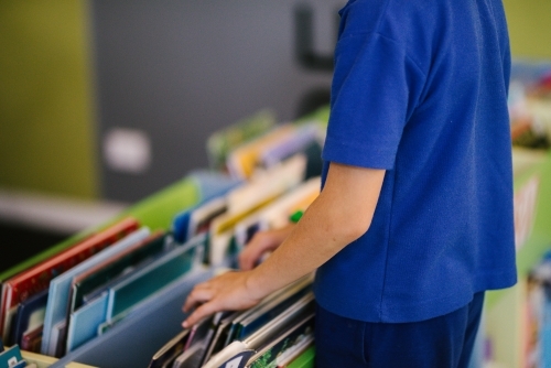 Primary student looking through books - Australian Stock Image