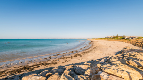 Pristine Robe Beach with distant people at sunset, Limestone Coast, South Australia - Australian Stock Image