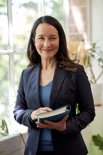 Professional business woman sitting at a computer in studio - Australian Stock Image