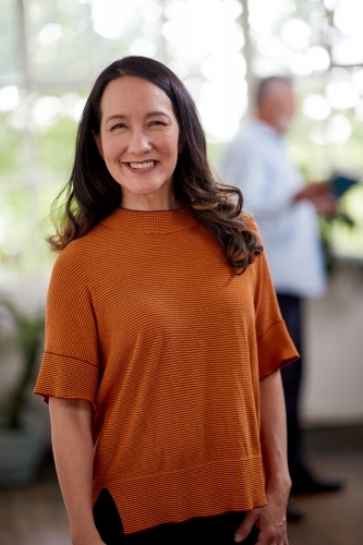 Professional business woman standing thinking in a studio office - Australian Stock Image