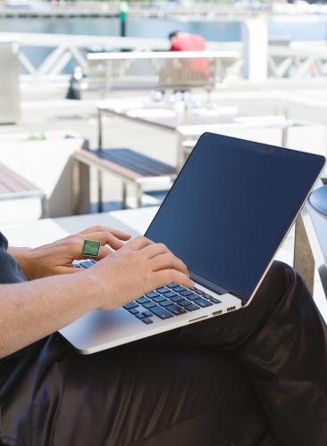 Professional woman working remotely on her laptop at an outdoor restaurant - Australian Stock Image