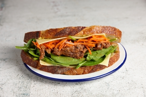 Pulled beef, cheese and salad sandwich on sourdough bread - Australian Stock Image