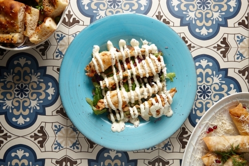 pumpkin flowers covered in mayonnaise on a blue plate - Australian Stock Image