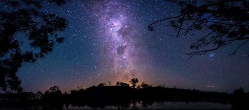Purple milky way behind bushland - Australian Stock Image