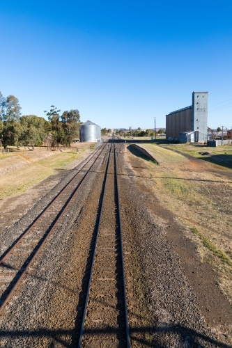 Railway lines leading up to industrial area with rail siding, platform and factory silos