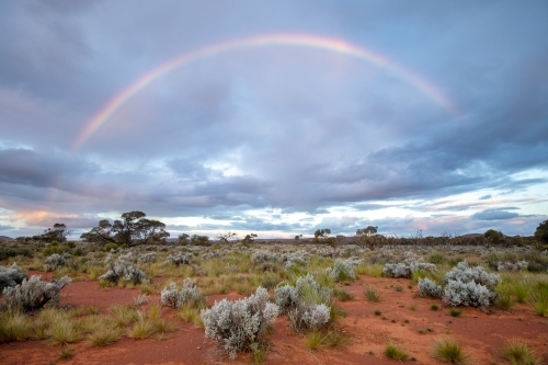 rainbow and storm clouds over outback landscape - Australian Stock Image