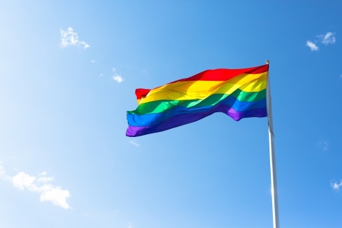 Rainbow flag against a blue sky