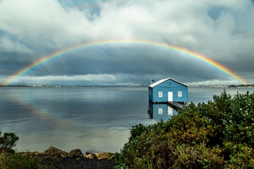 Rainbow over Crawley Edge blue boatshed, Perth, Western Australia, Australia - Australian Stock Image
