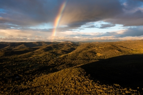 Rainbow over granite belt landscape - Australian Stock Image
