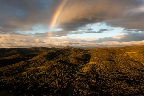 Rainbow over granite belt mountain landscape - Australian Stock Image