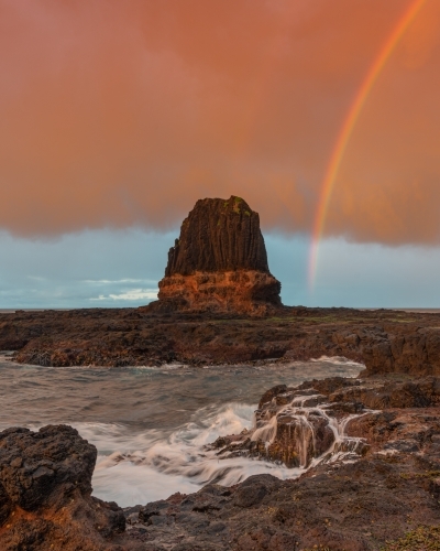 Rainbow over Pulpit Rock, Cape Schank at sunrise - Australian Stock Image