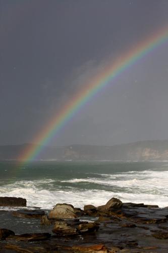 Rainbow over the ocean - Australian Stock Image