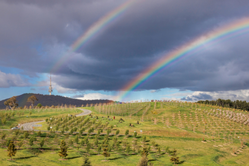 Rainbows over hills in Canberra - Australian Stock Image