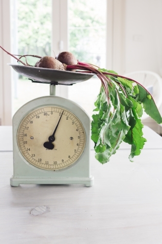 Raw beetroots on a set of vintage scales in a bright home