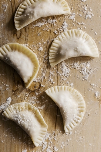 Raw dumplings on wood board - Australian Stock Image