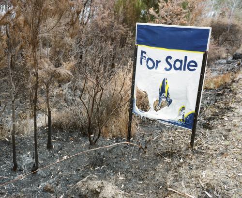 Real estate sign melted on bushfire scorched ground