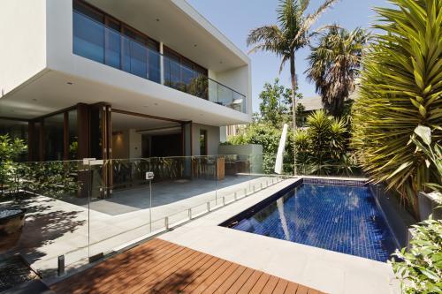 Rear landscaped yard with pool of architect designed home - Australian Stock Image