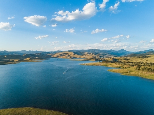 Recreation area beside dam, boat over water in Lake St Clair Hunter Valley - Australian Stock Image