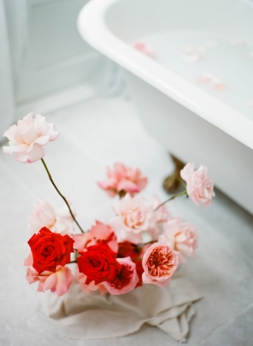 Red and pink roses by a french iron claw bath