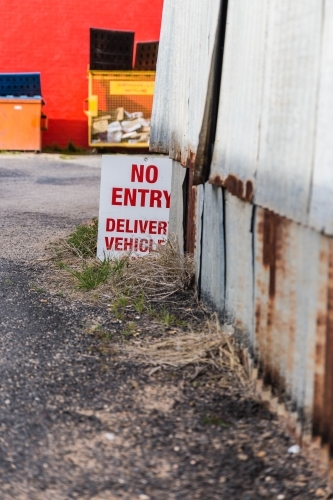 Red and white no entry sign next to rusty iron shed