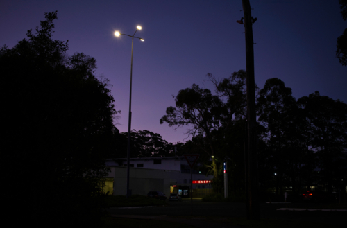 Red emergency sign illuminated at sunset - Australian Stock Image