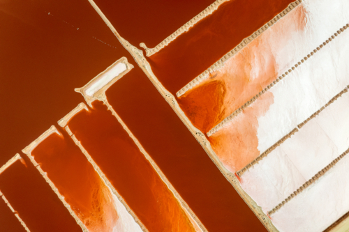 Red salt ponds divided by pale geometric walls - Australian Stock Image