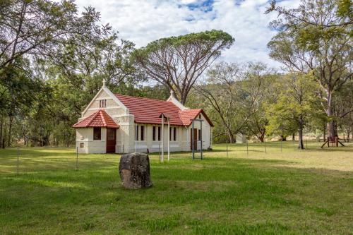 Reedy Creek Country Church among trees in the distance - Australian Stock Image