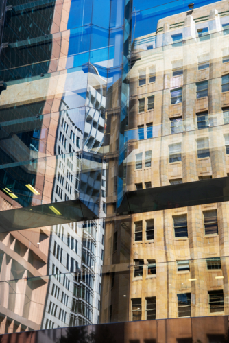 Reflection of old, sandstone building in the glass of a modern building - Australian Stock Image