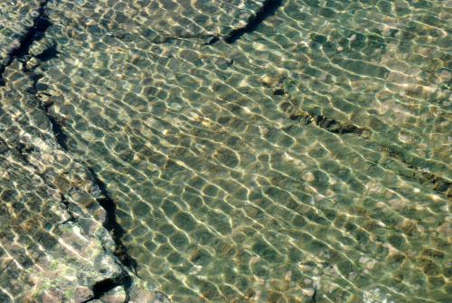 Reflection of sunlight in the water in a rock pool - Australian Stock Image