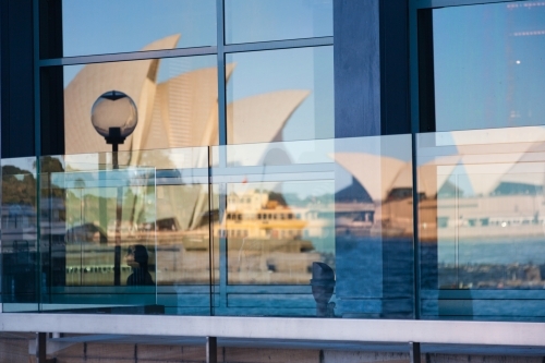 Reflection of the opera house and sydney ferry in windows at circular quay, sydney