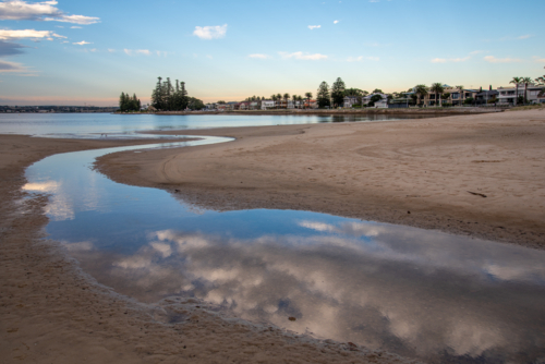 Reflections of clouds in water at Lady Robinsons Beach - Australian Stock Image