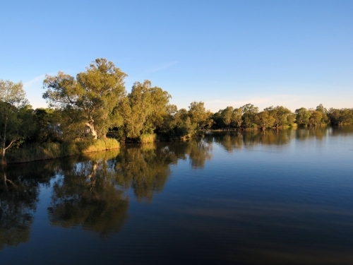 Reflections of trees on the Darling river, summertime dusk - Australian Stock Image