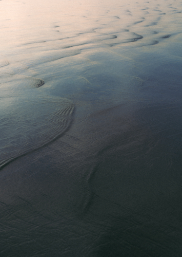 Reflective patterns on shallow water at beach - Australian Stock Image