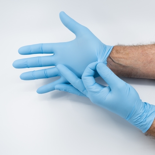 Removing blue medical gloves - Australian Stock Image