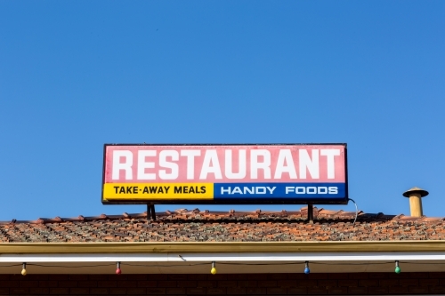 Restaurant sign on tiled roof with blue sky - Australian Stock Image