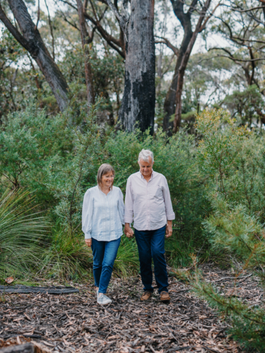 Retired senior couple walking together enjoying healthy lifestyle in nature - Australian Stock Image