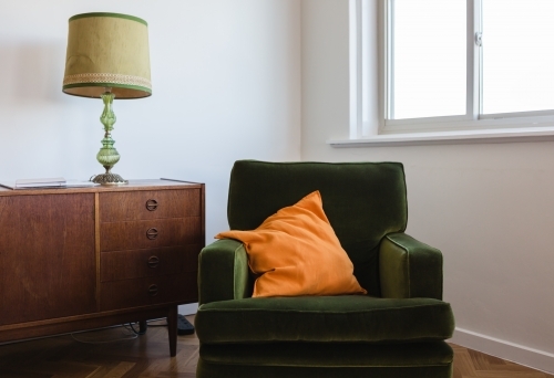 Retro living room furniture of a green velvet armchair and mid century buffet - Australian Stock Image