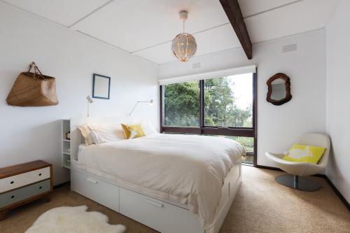 Retro styled guest bedroom in a 70s beach house shack - Australian Stock Image