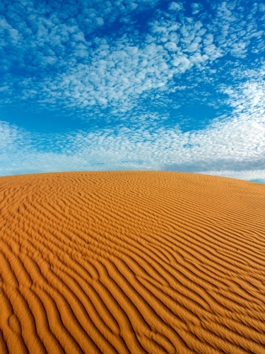 Ripples in a sandhill against blue sky