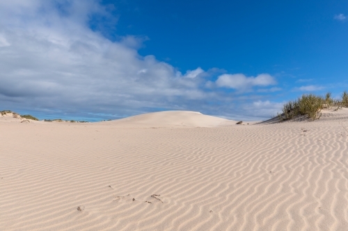 ripples in white sand dunes under blue sky