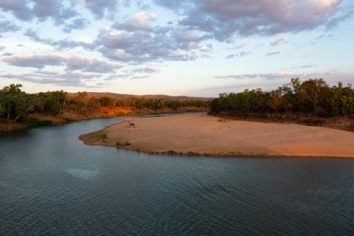 River winding around a sandy bank in rural area at sunset - Australian Stock Image