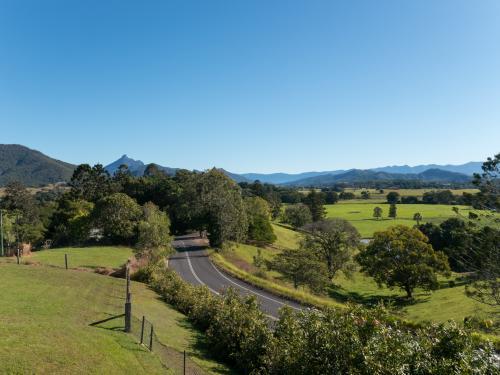 Road curving through a green fertile valley - Australian Stock Image