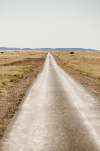 Road in the outback heading towards hills - Australian Stock Image